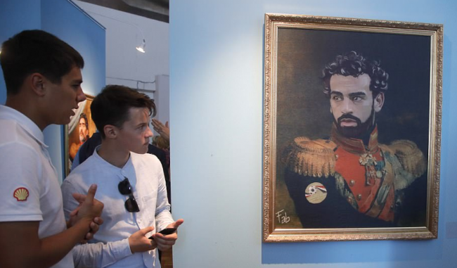 هنا صلاح يرتدي زياً تاريخياً مع ميسي ورونالدو ومارادونا.. أساطير كرة القدم في معرض للصور بروسيا