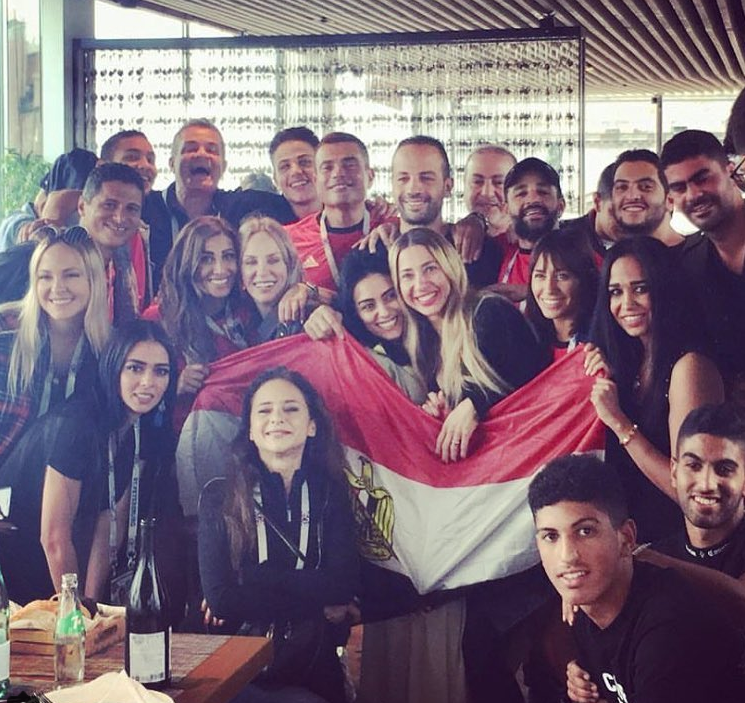 على هامش مباراة مصر وروسيا في كأس العالم 2018، تبدو دينا الشربيني وهي تضمّ شيرين رضا وسط مجموعة من المشاهير/إنستغرام