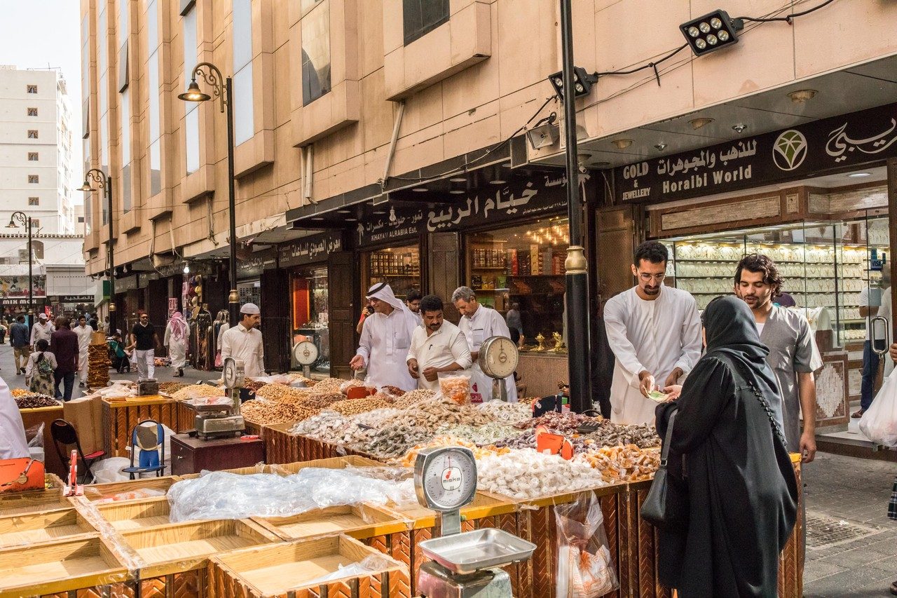 عملاء يشترون الحلوى والمكسرات في جدة استعدادا للعيد