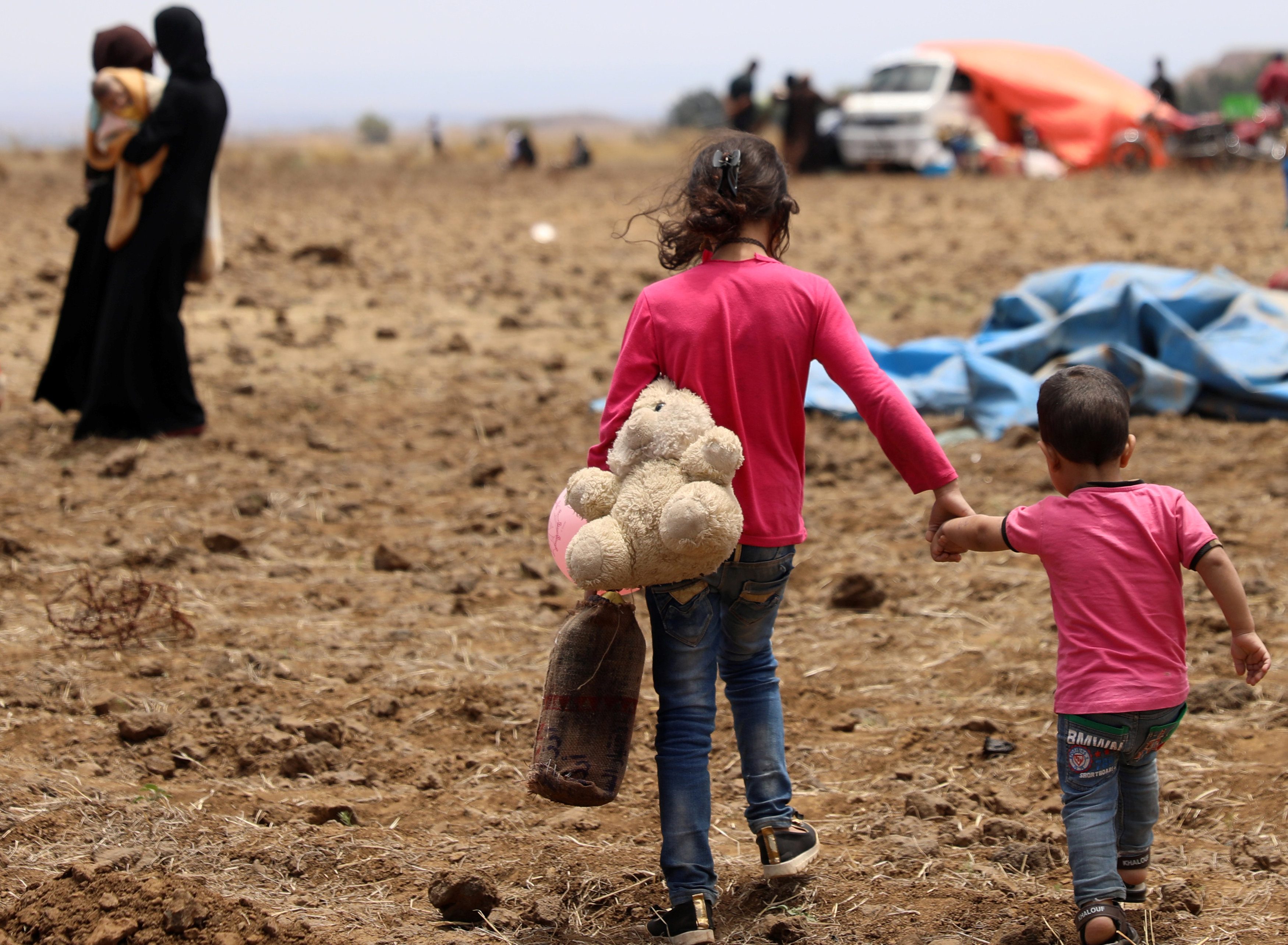 أطفال درعا يلعبون تحت أشعة الشمس الحارقة على الحدود مع الأردن