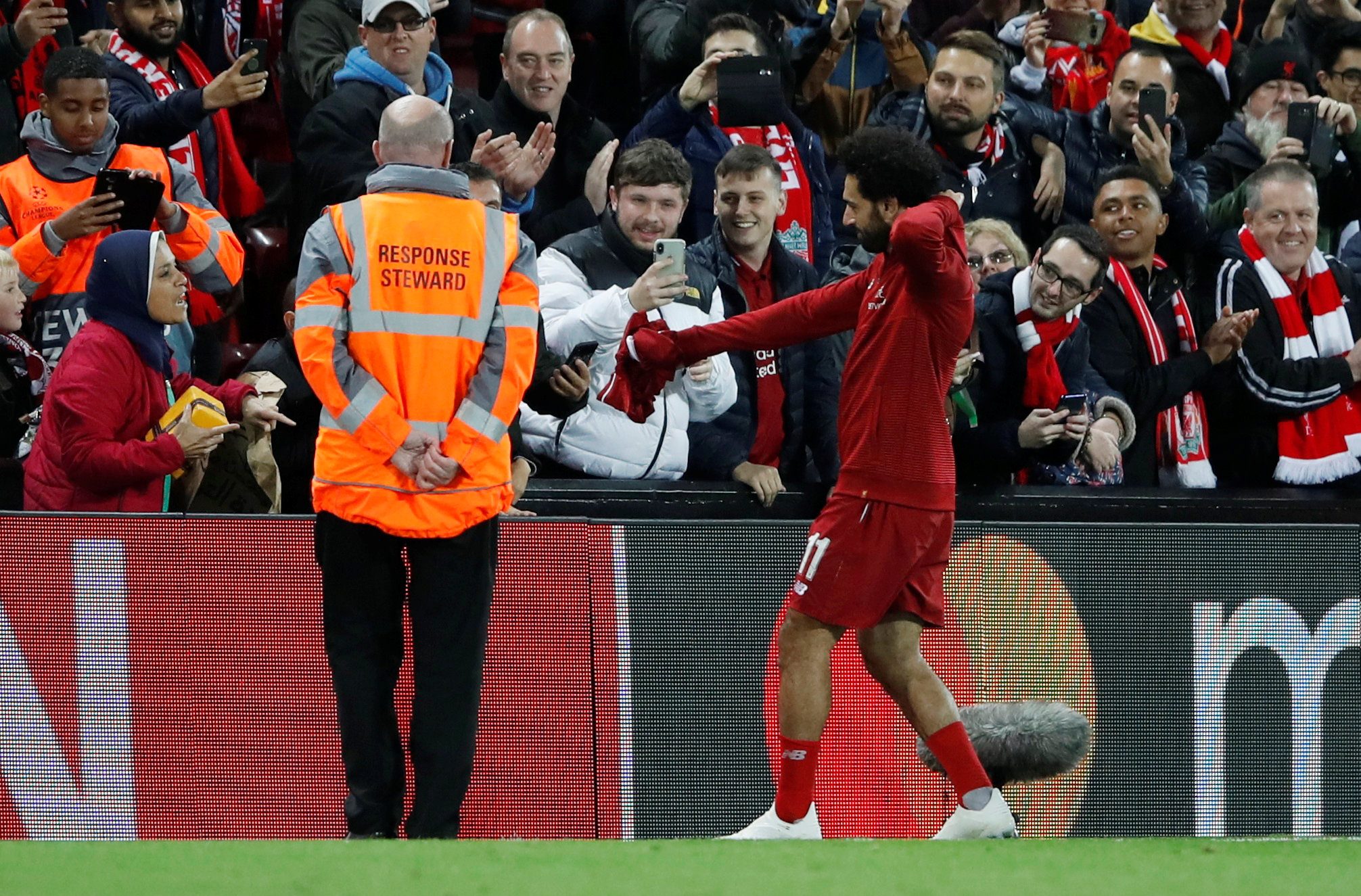 محمد صلاح مع مشجعة مصرية في مباراة ليفربول وريدستار بيلغراد ضمن دوري أبطال أوروبا (رويترز)