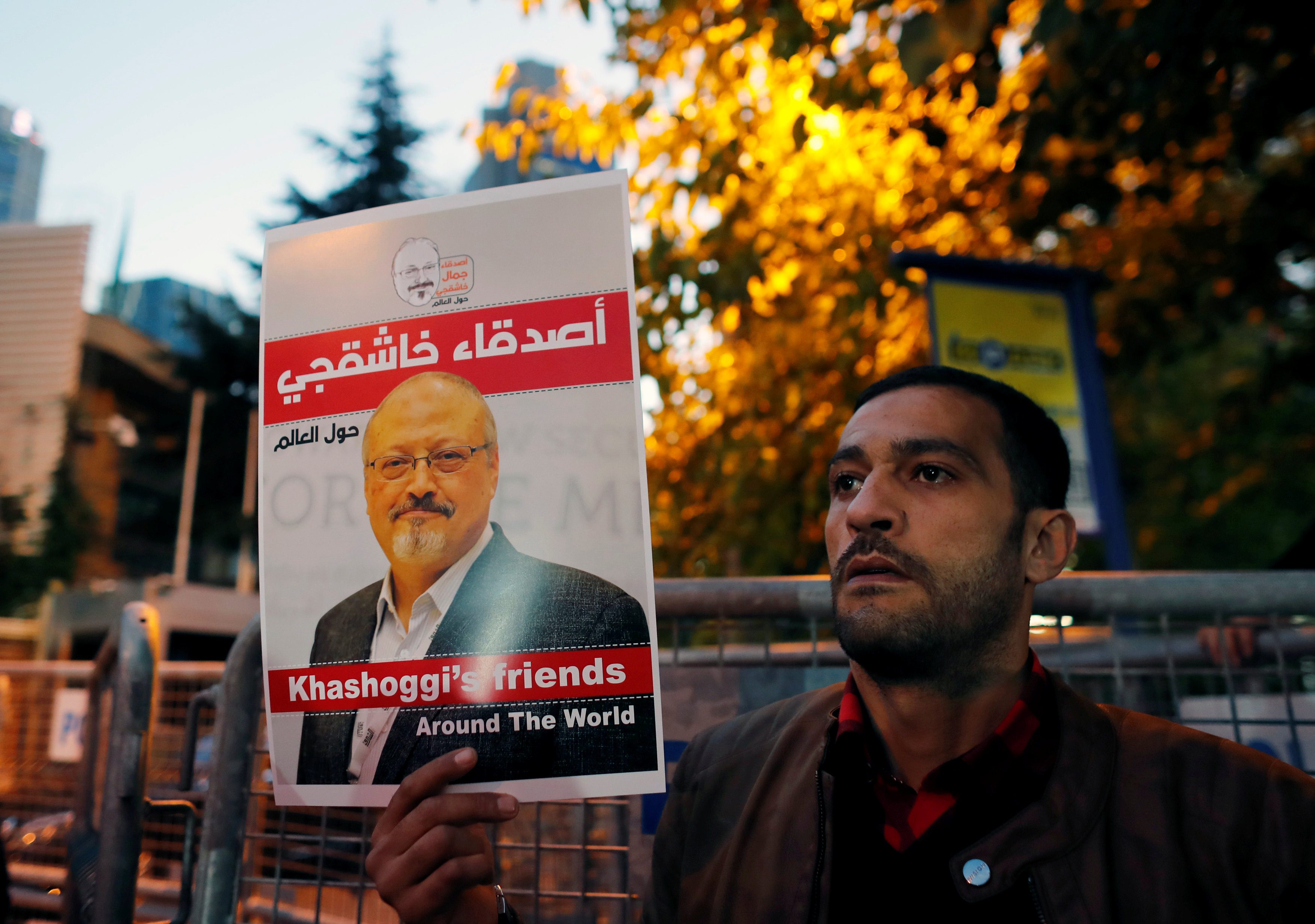 متظاهر يحمل ملصقاً عليه صورة خاشقجي خارج القنصلية السعودية في اسطنبول