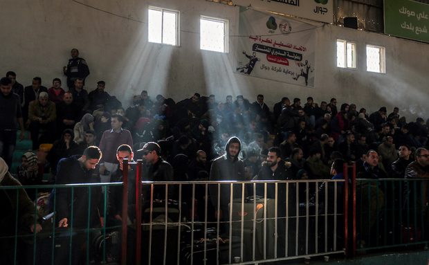 فلسطينيون ينتظرون الحافلة التي ستقلهم غلى معبر رفح / رويترز