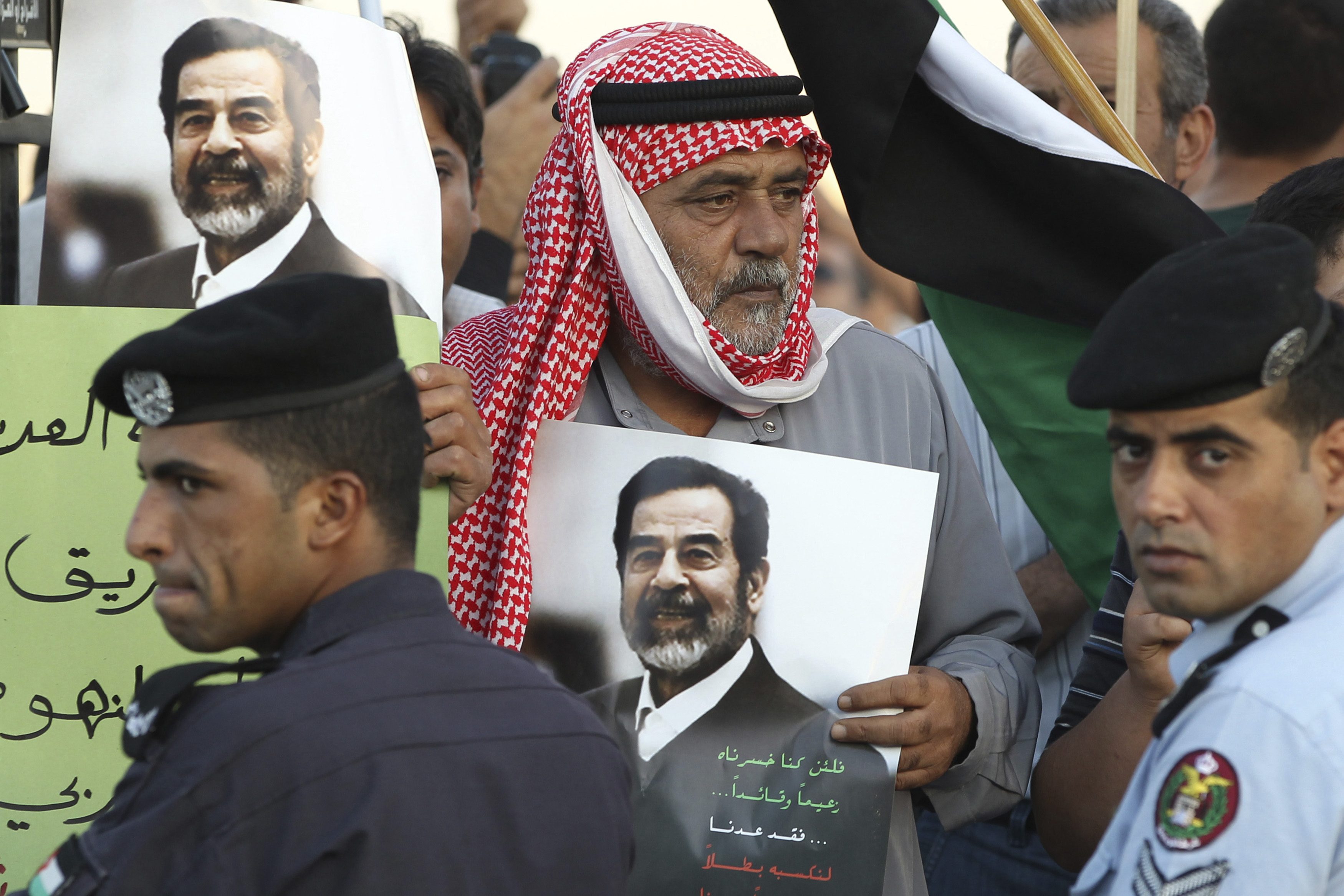 أردني يحمل صورة للرئيس العراقي السابق صدام حسين (رويترز)