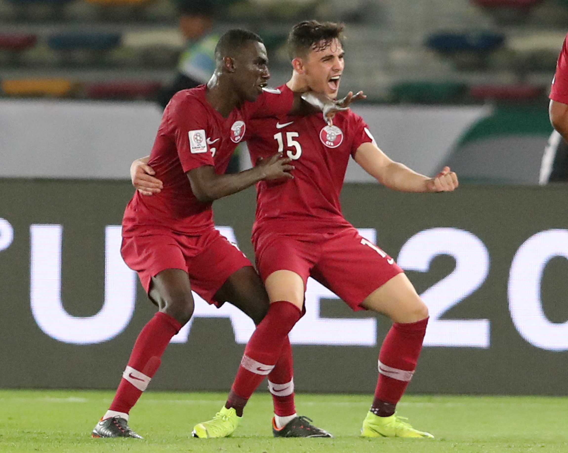 المعز علي يحتفل بفوز قطر على السعودية مع زميله بسام هشام (رويترز)