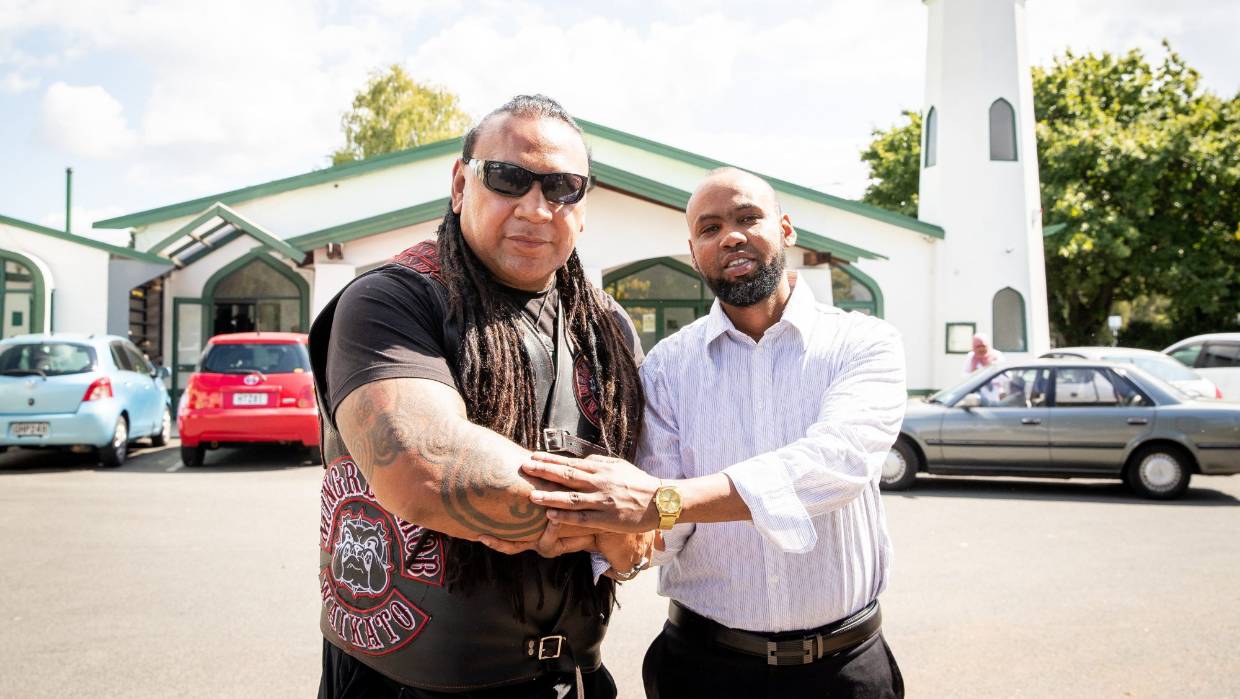 أحد أفراد عصابة مونغريل موب (Mongrel Mob) مع أحد المصلين في المسجد/صحيفة Stuff النيوزيلندية