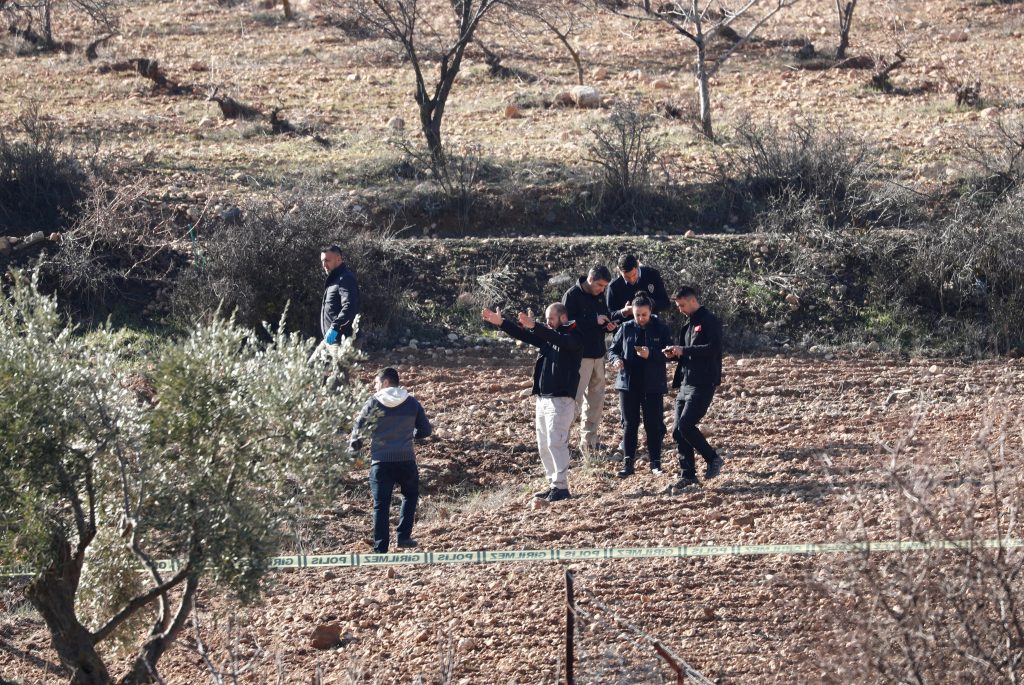 رجال شرطة يرتدون ملابس مدنية وخبراء الطب الشرعي يتفحصون بعد أن سقط صاروخ أطلق من سوريا على حقل قرب بوابة أونكوبينار الحدودية على الحدود التركية السورية في كيليس