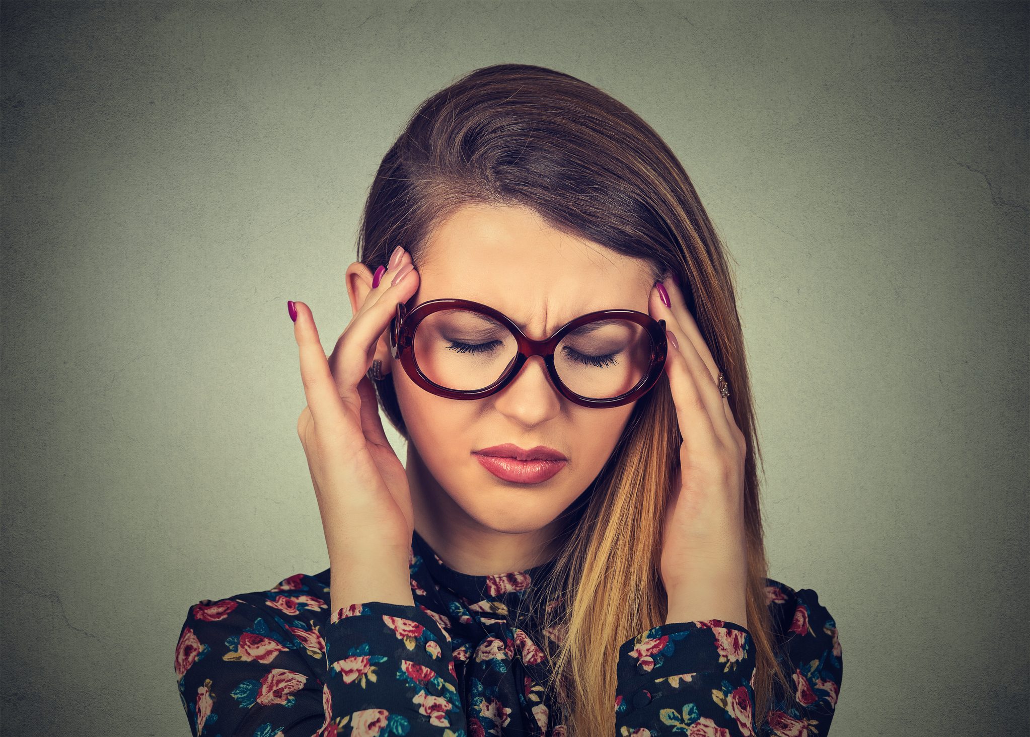 أمرأة تمسك برأسها تعاني من الضغط الذهني