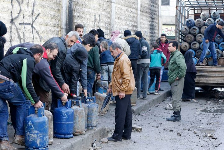 سوريون يقفون في طوابير للحصول على إسطوانات الغاز في حلب/ AFP 