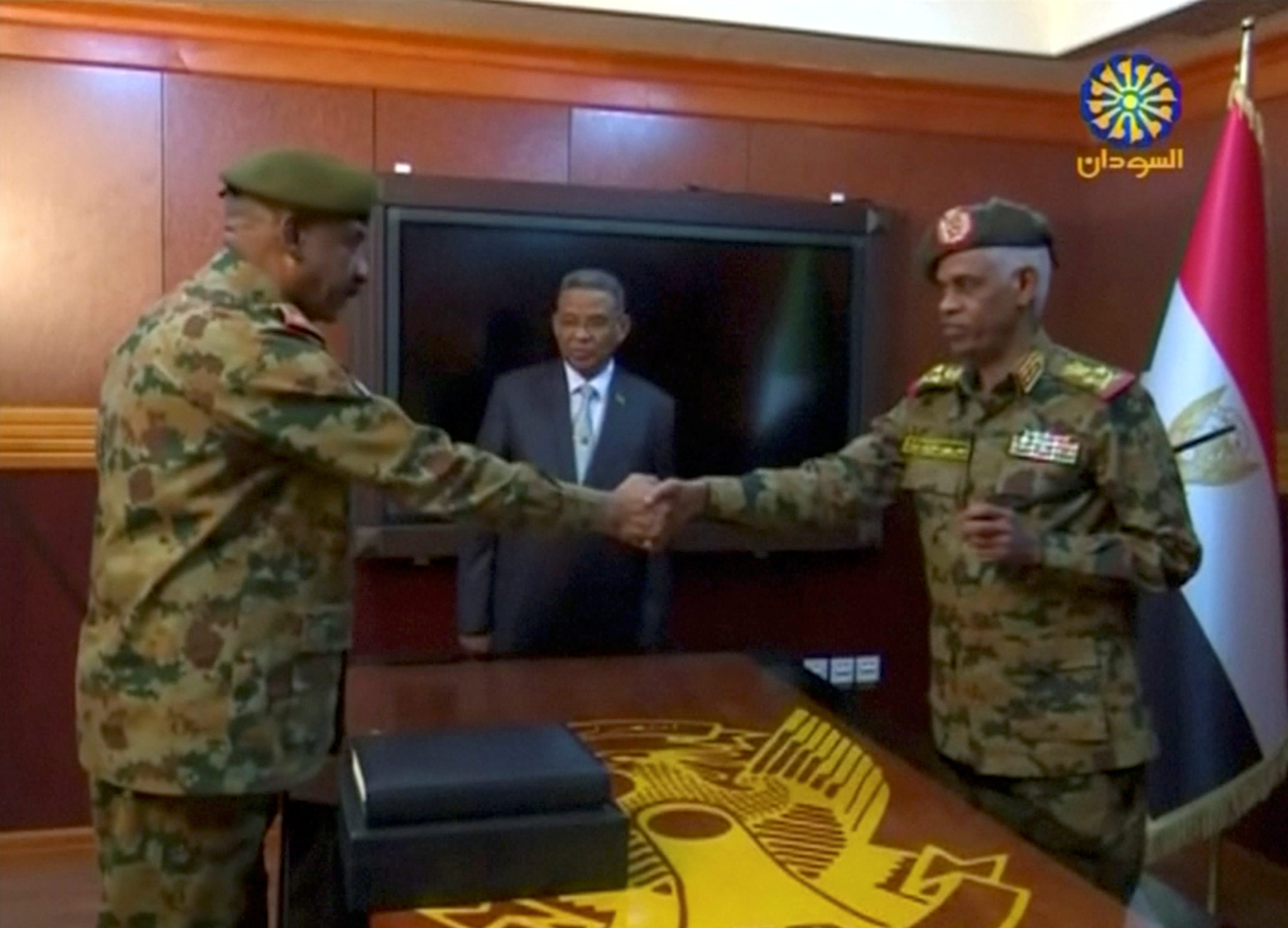 وزير الدفاع السوداني عوض محمد أحمد بن عوف ، رئيس المجلس الانتقالي العسكري ورئيس أركان الجيش ، الفريق كمال عبد الرؤوف الماحي يتصافحان بعد أداء اليمين الدستورية كقائد للمجلس الانتقالي العسكري في السودان