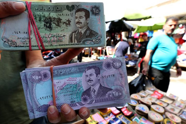 بائع عراقي يعرض أوراق نقدية عراقية قديمة تحمل صورة الرئيس العراقي السابق صدام حسين للبيع في سوق باب الشرقي بوسط بغداد، 2018/ AFP