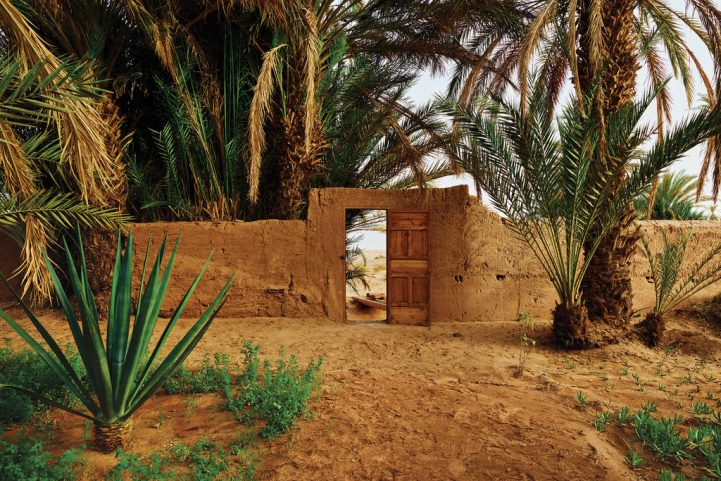 الحديقة المسورة في فندق دار بارو في مدينة محاميد الغزلان جنوب المغرب، مع باب يفتح على الصحراء/ نيويورك تايمز