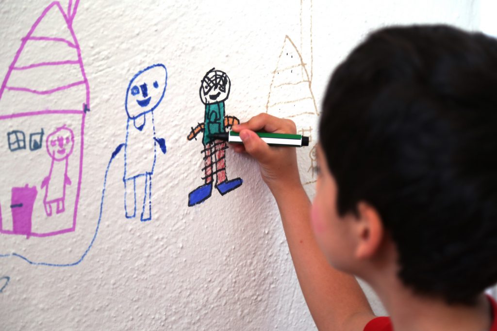 طفل صغير يرسم على الجدار / iStock