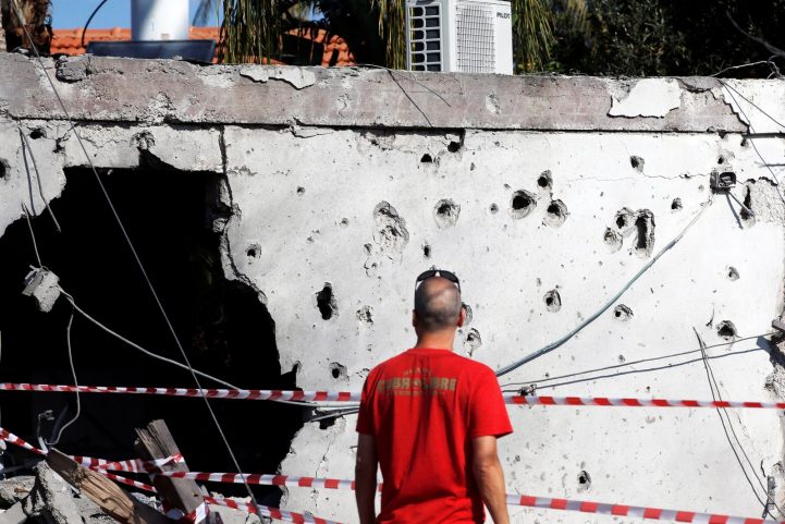 مستوطن إسرائيلي يقف أمام مبنى مدمر في أشكول، جراء سقوط صاروخ فلسطيني عليه من غزة، نوفمبر 2018/ رويترز