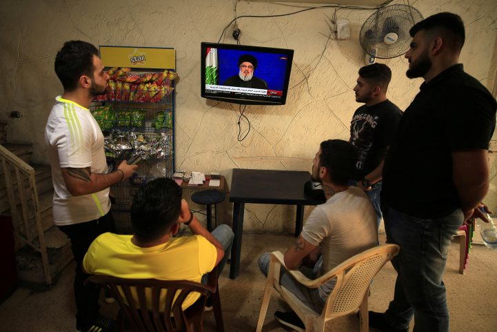 لبنانيون يستمعون لكلمة زعيم حزب الله/ رويترز