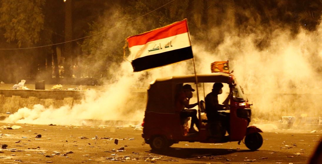 توك توك يبتعد عن الغاز المسيل للدموع الذي أطلقته قوات الأمن العراقية خلال احتجاج على الفساد ونقص الوظائف وضعف الخدمات في بغداد