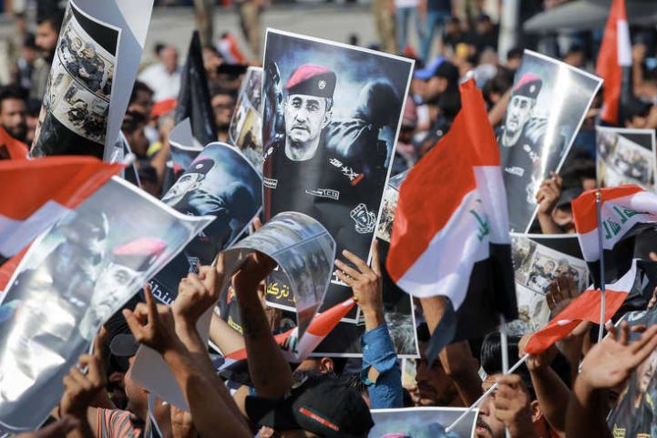 متظاهرون عراقيون يرفعون صور الفريق الساعدي خلال تظاهرات ضد الحكومة وسط بغداد/ Getty