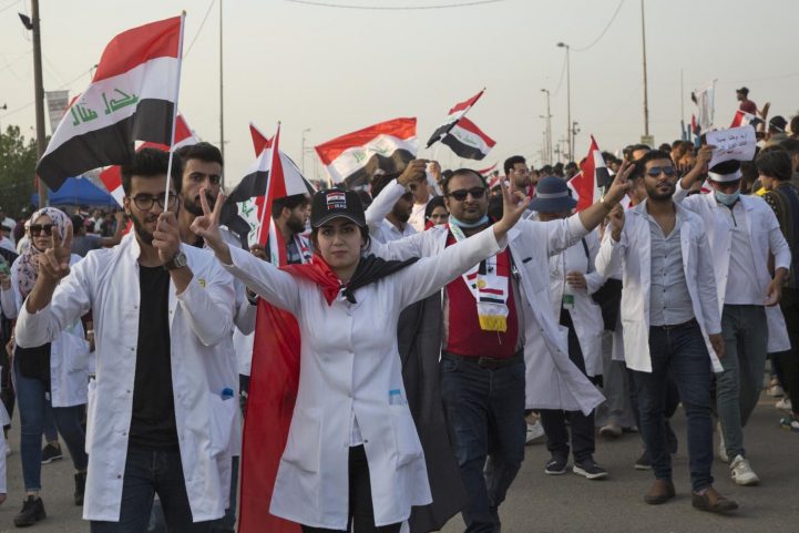 الأطباء والصيادلة العراقيون يلوحون بعلامة النصر والأعلام في البصرة في 30 أكتوبر (وكالة الصحافة الفرنسية)