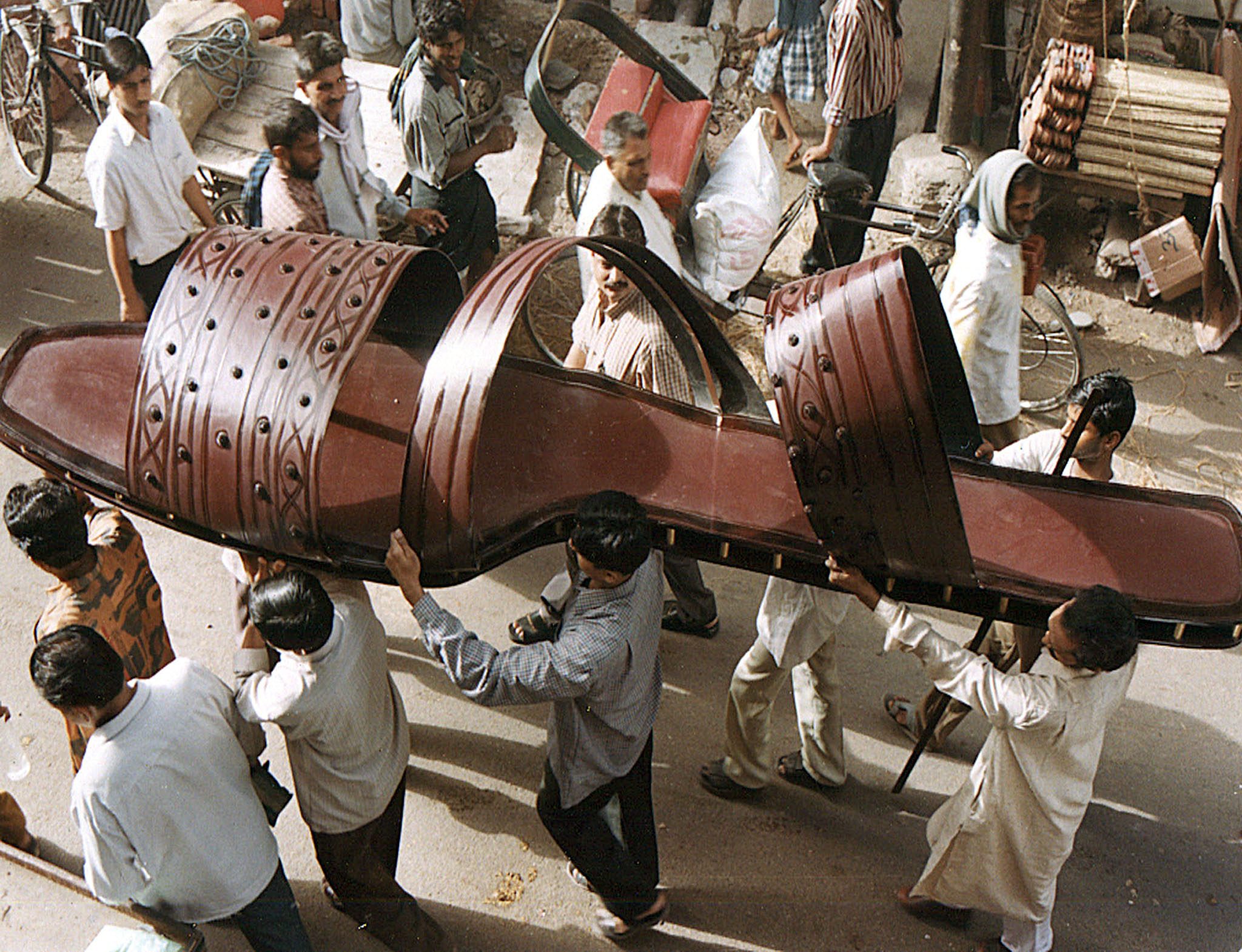 هنود يحملون شبشب عملاق للعرض العلني من خلال شارع في مدينة أغرا الهندية الشمالية لما يعتقد أنه أكبر شبشب في العالم/رويترز