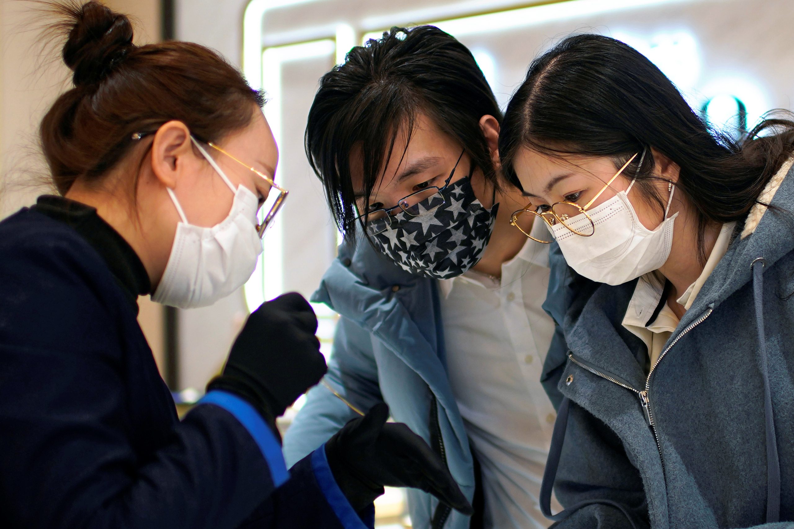 ينظر وانغ ، 32 عامًا ، وزوجته شي ، 30 عامًا ، يرتديان أقنعة إلى قلادة في مركز تجاري في عيد الحب في شنغهاي/رويترز