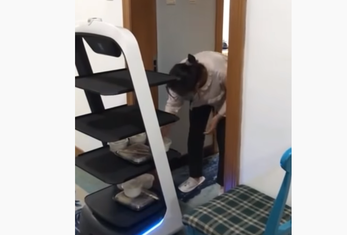 لا يحتكّون بهم بل يرسلون لهم الآلات لتقديم الطعام.. شاهد كيف تنقل الصين الغذاء للمصابين بـ “كورونا”