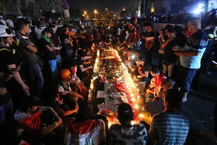 محتجون عراقيون يجتمعون حول نصب للشهداء الذين سقطوا برصاص الأمن، ساحة التحرير بغداد/ رويترز
