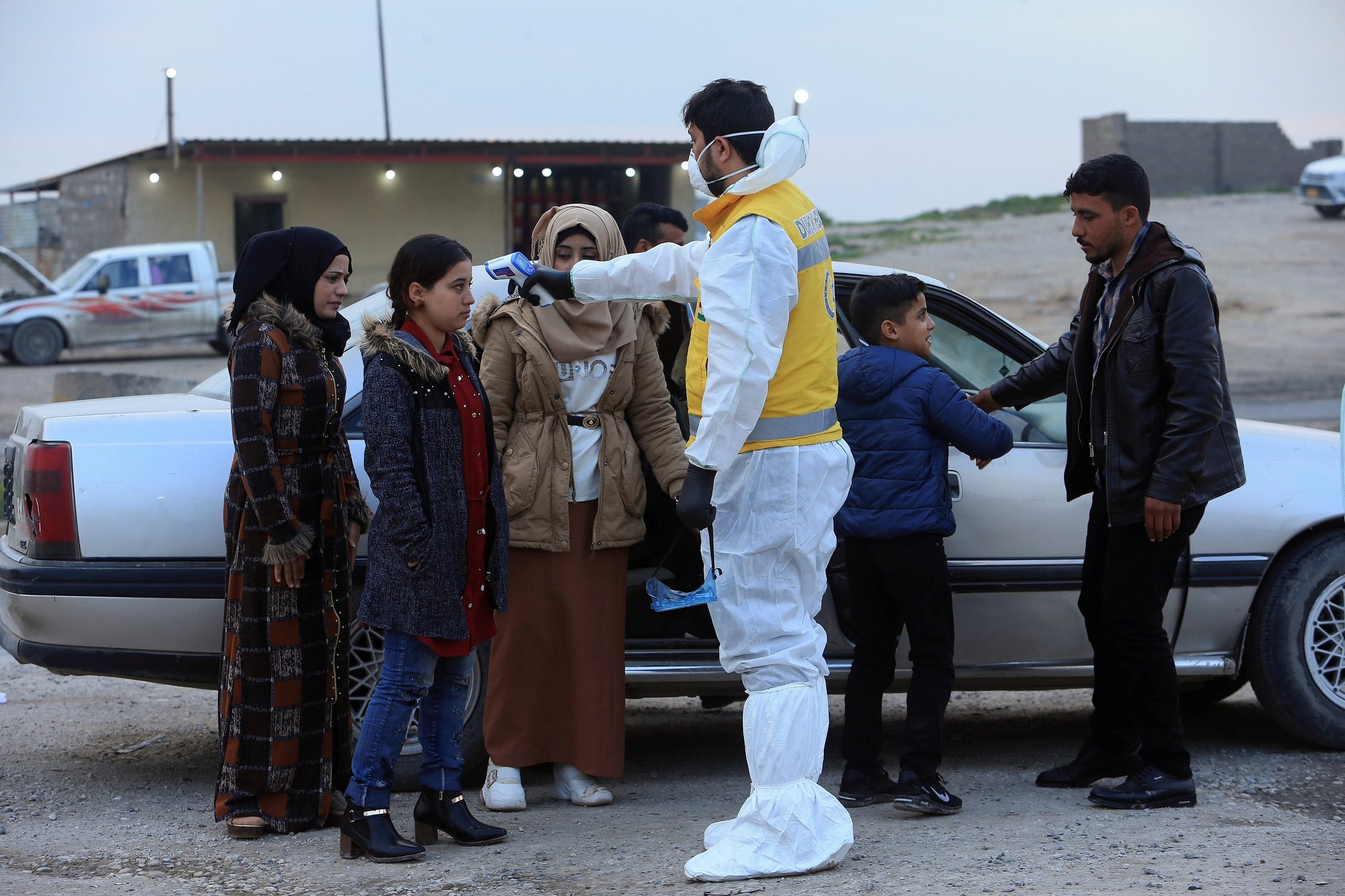 أحد أعضاء الفريق الطبي يفحص درجة حرارة الأشخاص ، بعد تفشي فيروس كورونا ، عند نقطة تفتيش في ضواحي دهوك ، العراق ، 2 مارس / آذار 2020. رويترز