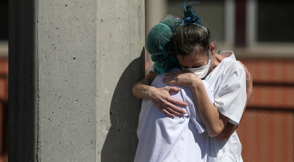 أطباء يعانقون بعضهم خارج غرف الطوارئ في مستشفى بمدينة ليغانيس