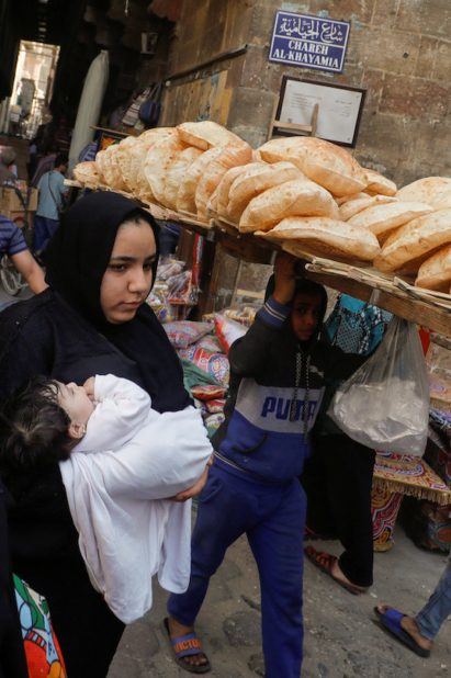 بائع يحمل الخبز في شارع الخيامية بالقاهرة/ رويترز