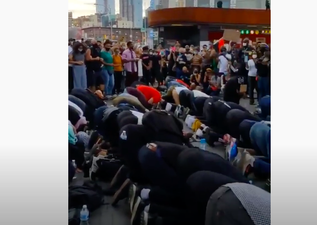 التفوا حولهم وشكلوا جداراً بشرياً عازلاً.. متظاهرو أمريكا يحمون المسلمين لأداء الصلاة  باحتجاجات نيويورك(فيديو)