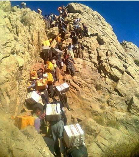 يحملون البضائع على ظهورهم 10 ساعات كل يوم والعشرات منهم يلقون حتفهم! مأساة ممتهني “الكولبار” على حدود إيران والعراق