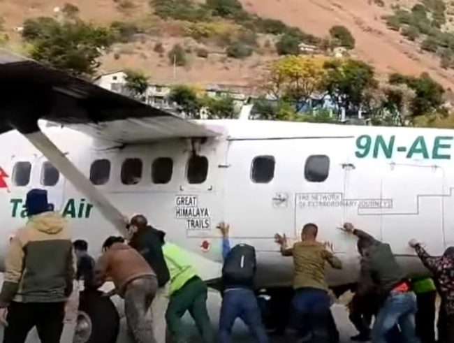 مشهد غريب قد لا تشاهده في أي مكان.. ركاب يدفعون طائرة للأمام لمساعدتها على الإقلاع! (فيديو)