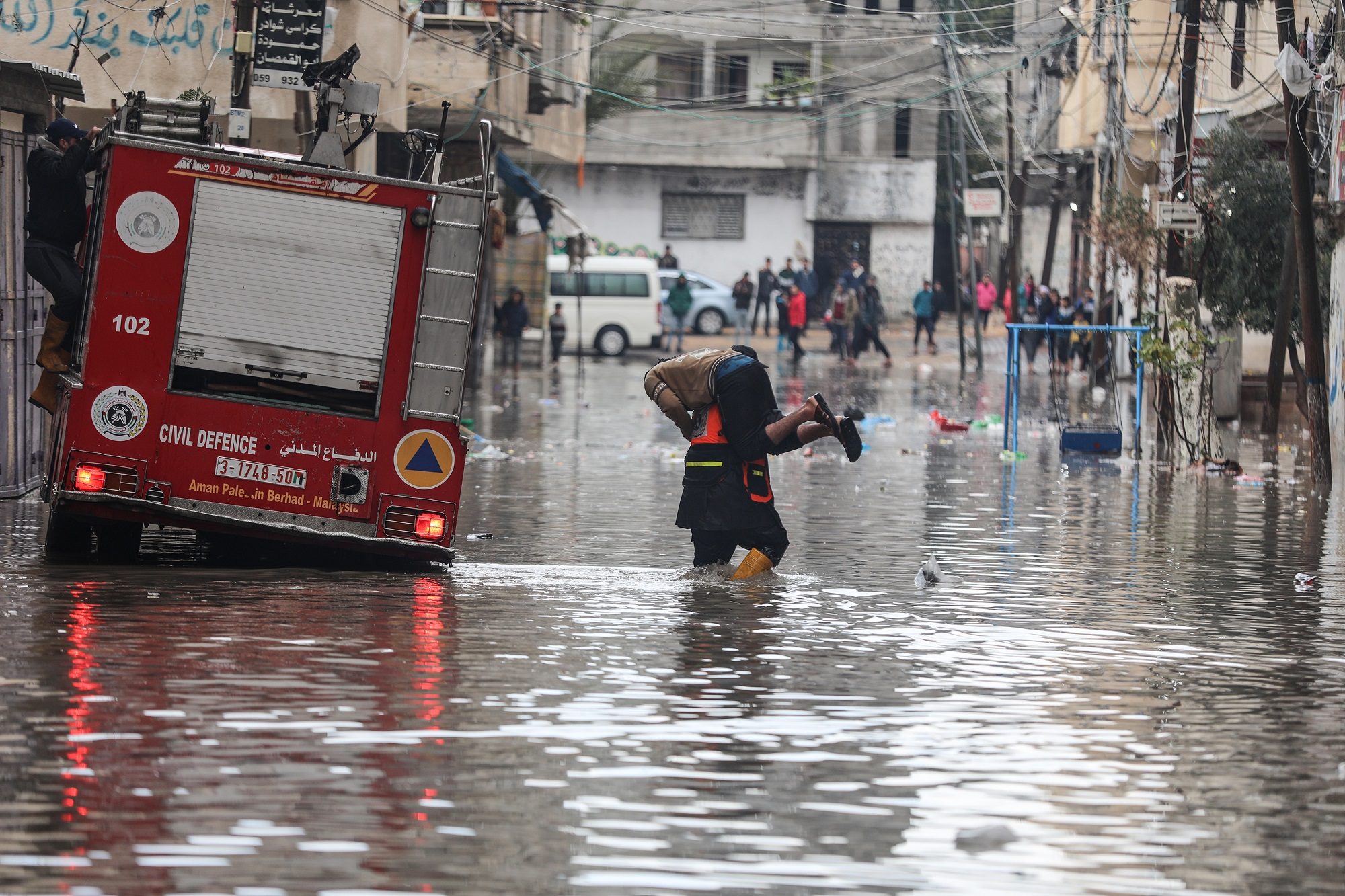 استُخدمت القوارب الخشبية للتنقل! أمطار غزيرة تغمر شوارع غزة التي دمرها العدوان الإسرائيلي الأخير (فيديو)