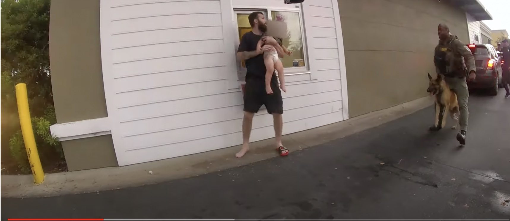 احتضن طفله “العاري” وهدد الأمن! أمريكي يتخذ ابنه درعاً بشرية ضد عناصر شرطة حاصروه بالكلاب البوليسية (فيديو)