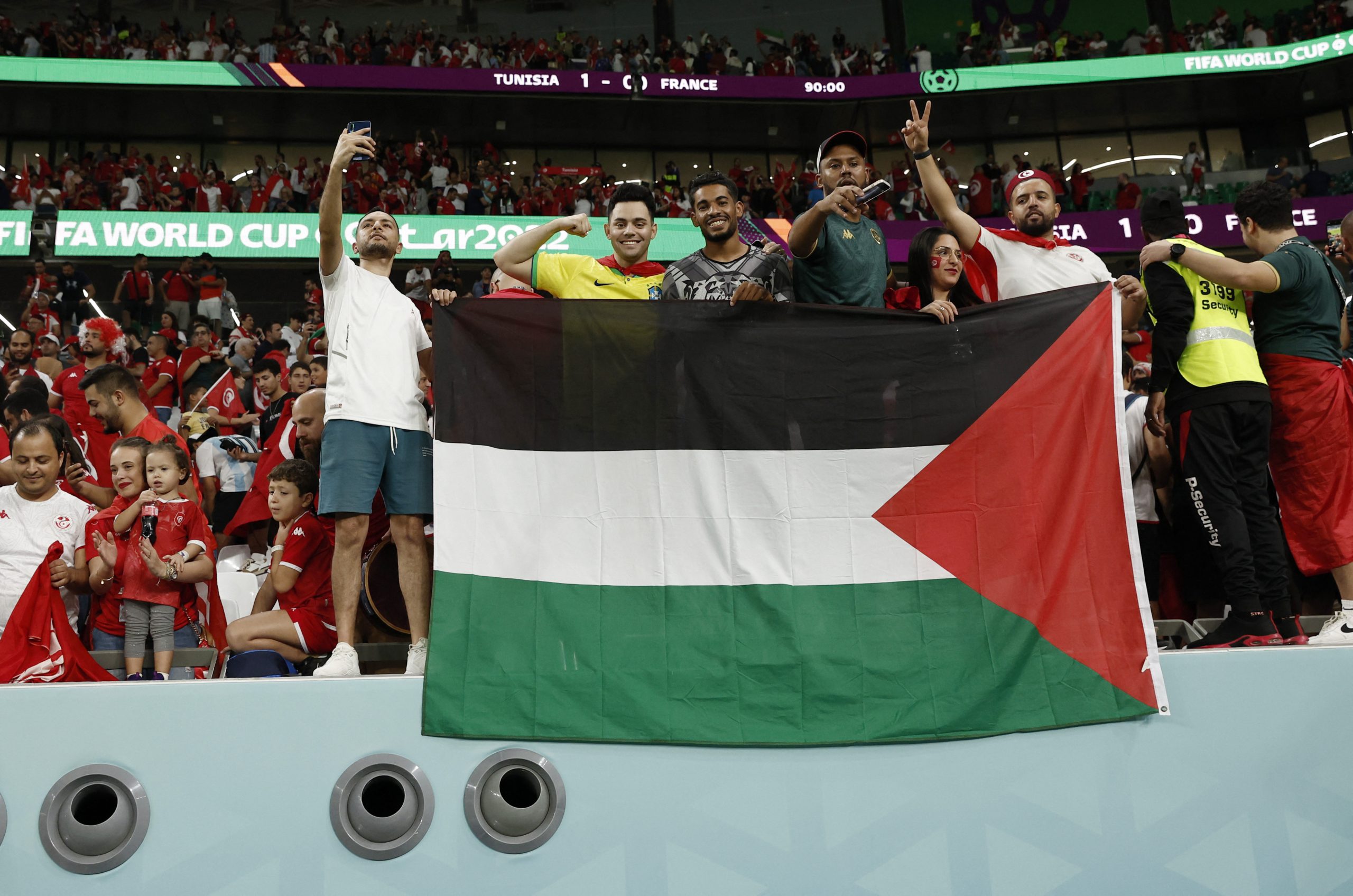 مشجع تونسي يدخل الملعب حاملاً علم فلسطين (رويترز)