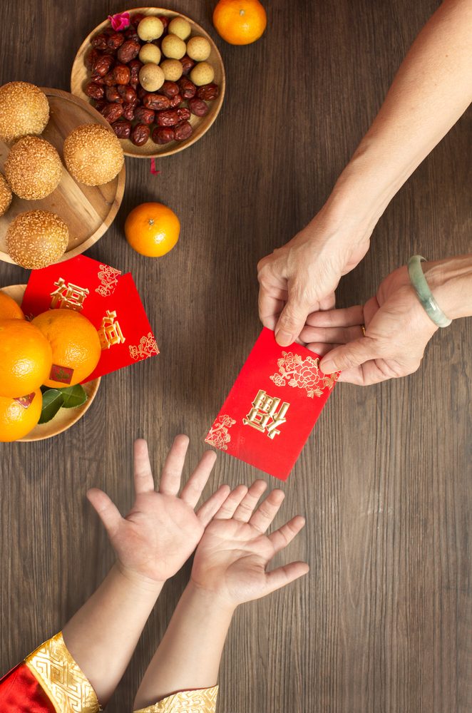 تبادل الأظرف الحمراء من تقاليد العيد القمري للعام الصيني الجديد - Shutterstock