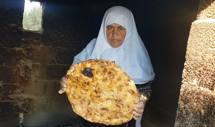 سيدة فلسطينية تحمل خبز الصاج بين يديها