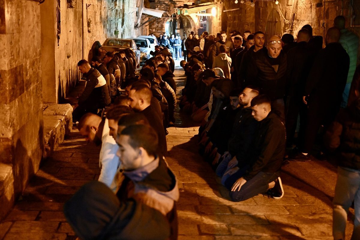 فلسطينيون يصلون بالقرب من أحد أبواب الأقصى بعد منعهم الدخول إليه/الأناضول