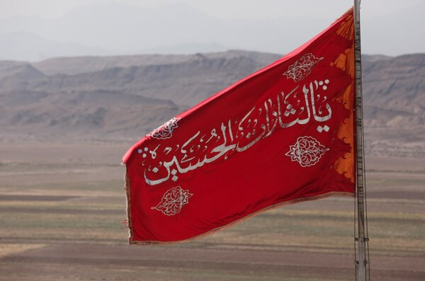 العلم الأحمر يحمل عبارة "يالثارات الحسين"