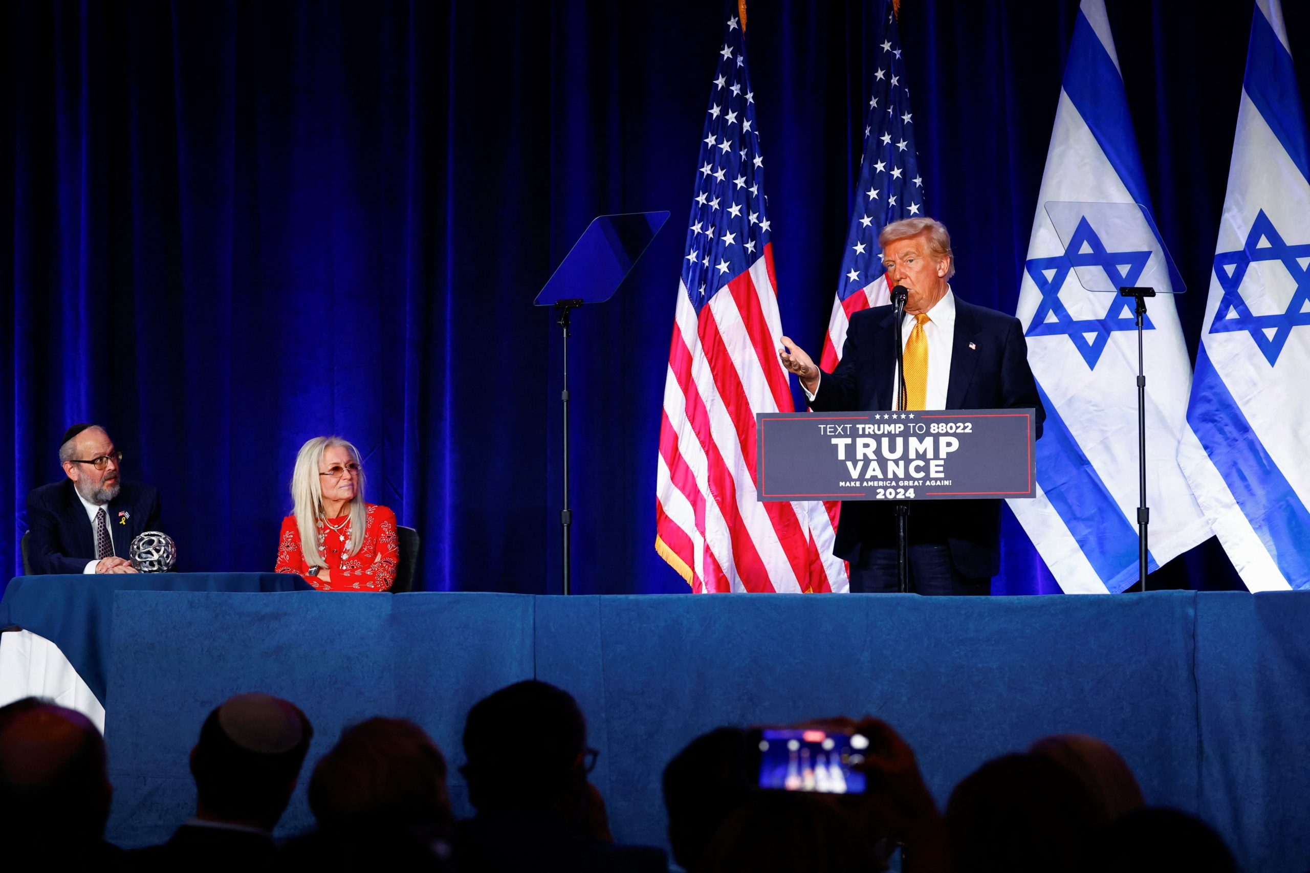 دونالد ترامب يتحدث خلال فعالية صهوينية بينما تجلس على يمينه ميريام أديلسون وقادة يهود في واشنطن - رويترز