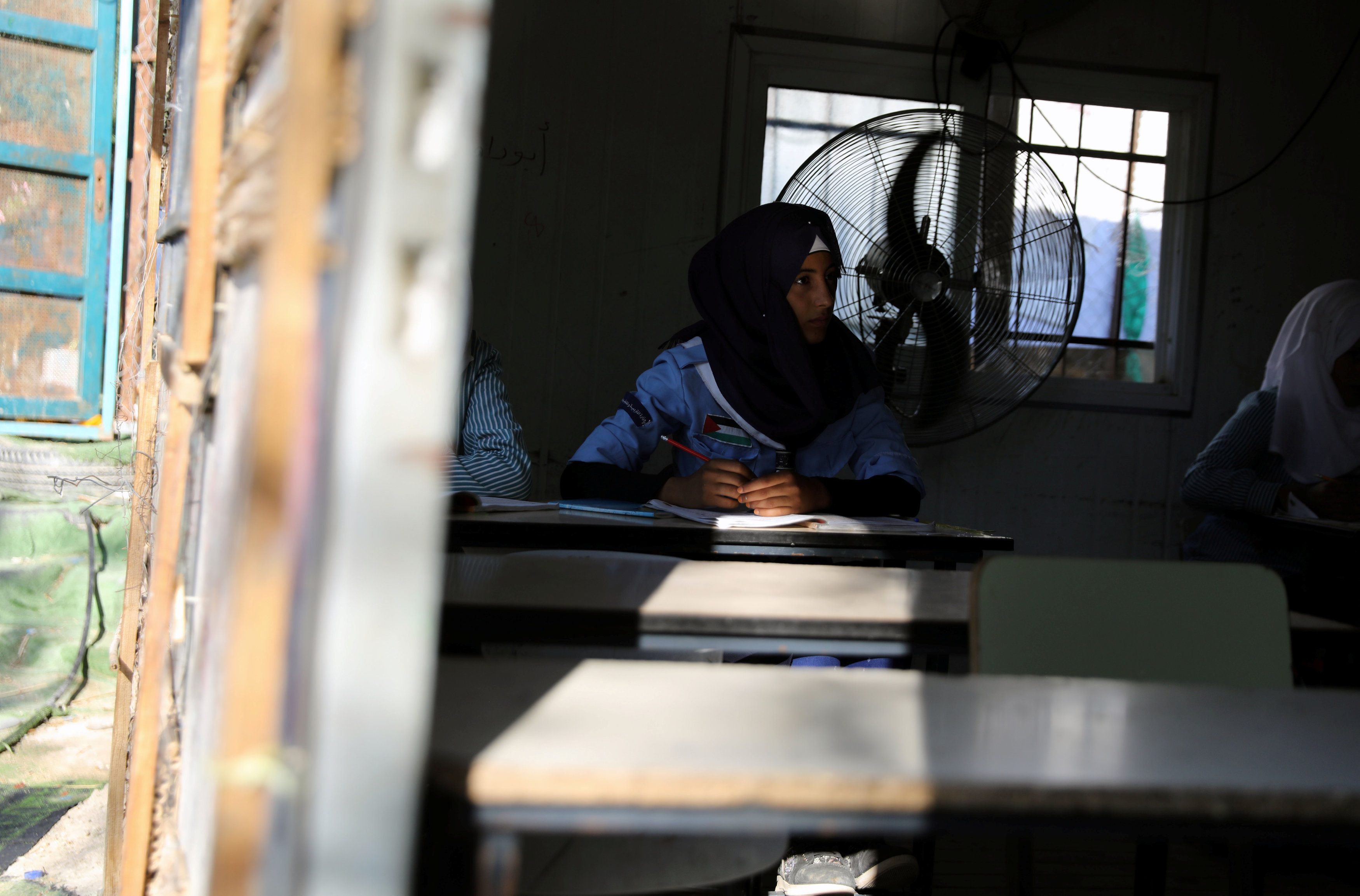 فتاة فلسطينية تحضر درسا داخل إحدى الفصول في مدرستها في قرية خان الأحمر البدوية في الضفة الغربية المحتلة