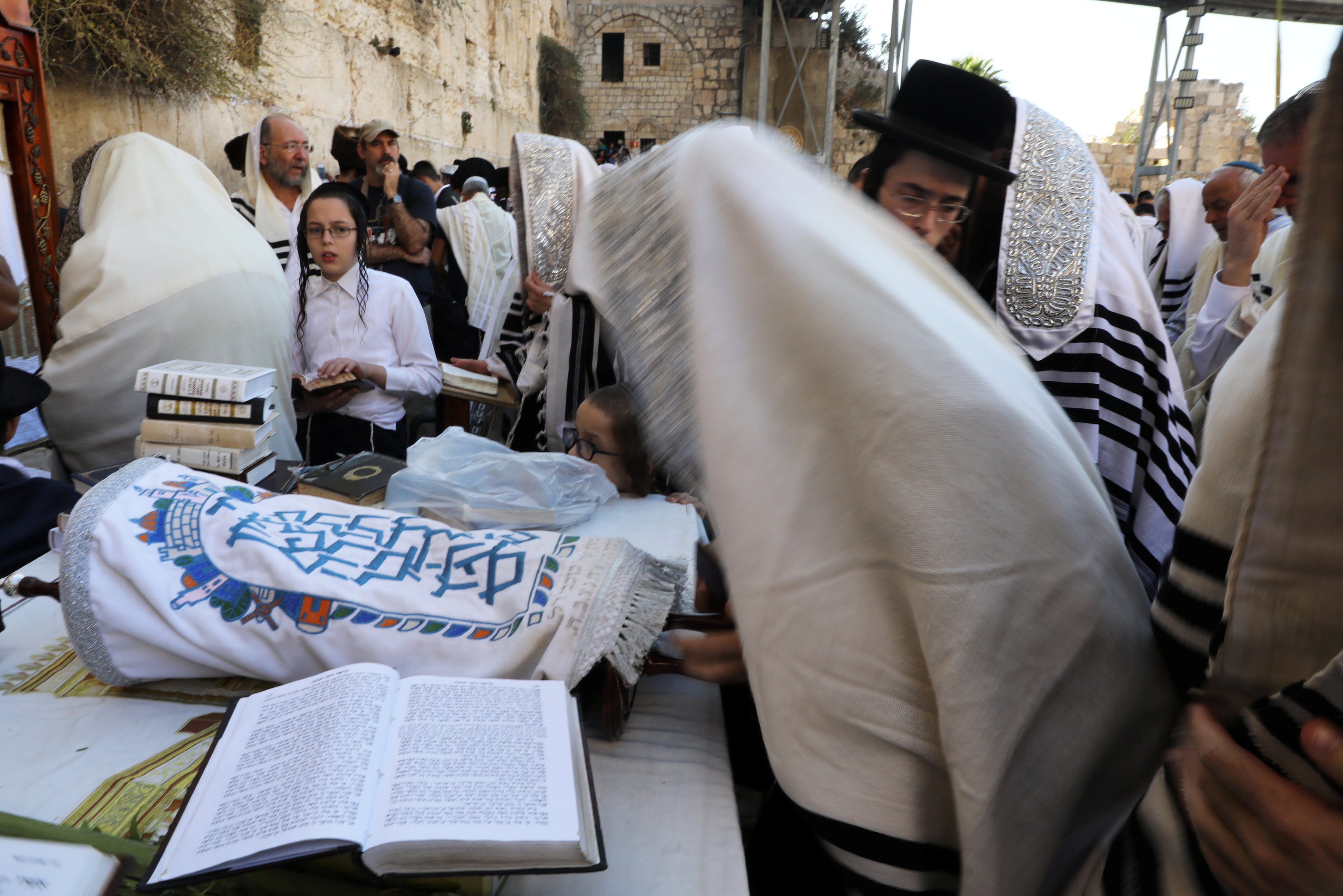 متعبدون يهود يمارسون طقساً دينياً عن حائط البراق في مدينة القدس (رويترز)